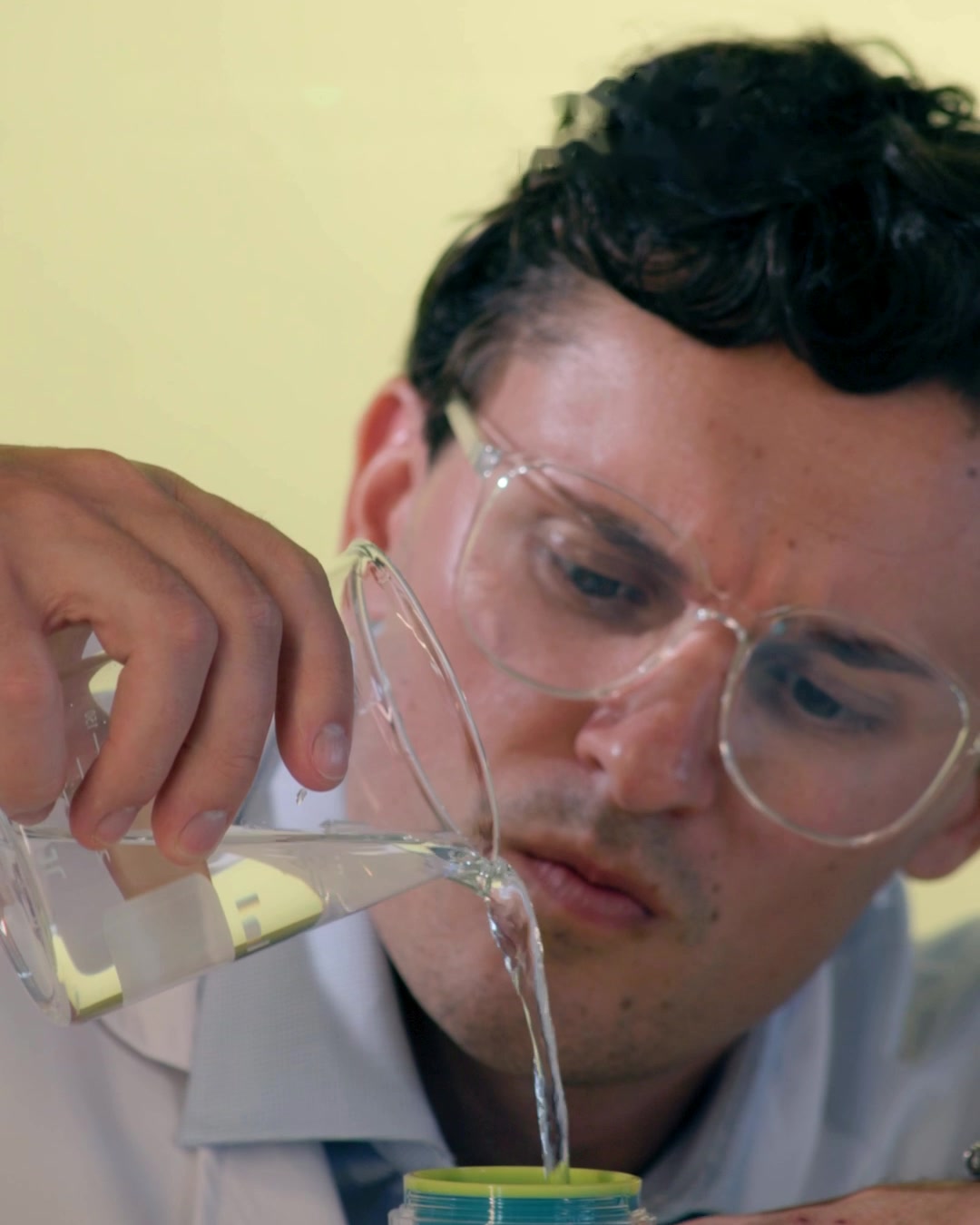 Michael, co-founder, wearing safety glasses and pouring water into a jar of Active Restore Cream