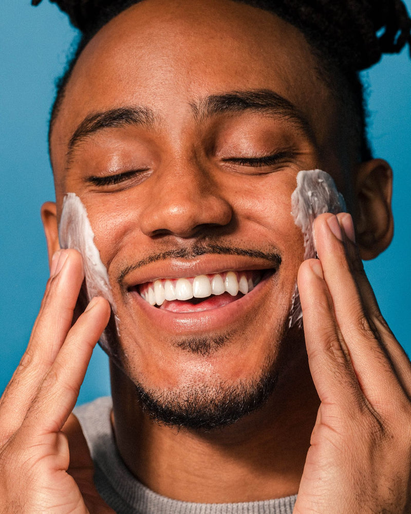 Man smoothing Active Restore Cream onto both cheeks